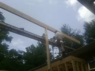 Carpenter setting a ridge beam over a new addition frame — Ice Dam Removal by Roofing Brothers in Leawood