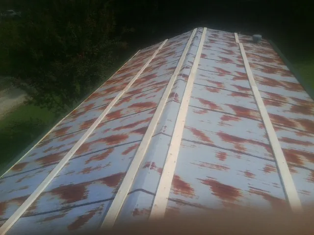 Rusted metal roof panels with new wood purlins before replacement — Storm Damage Roof Repair in Leawood by Roofing Brothers