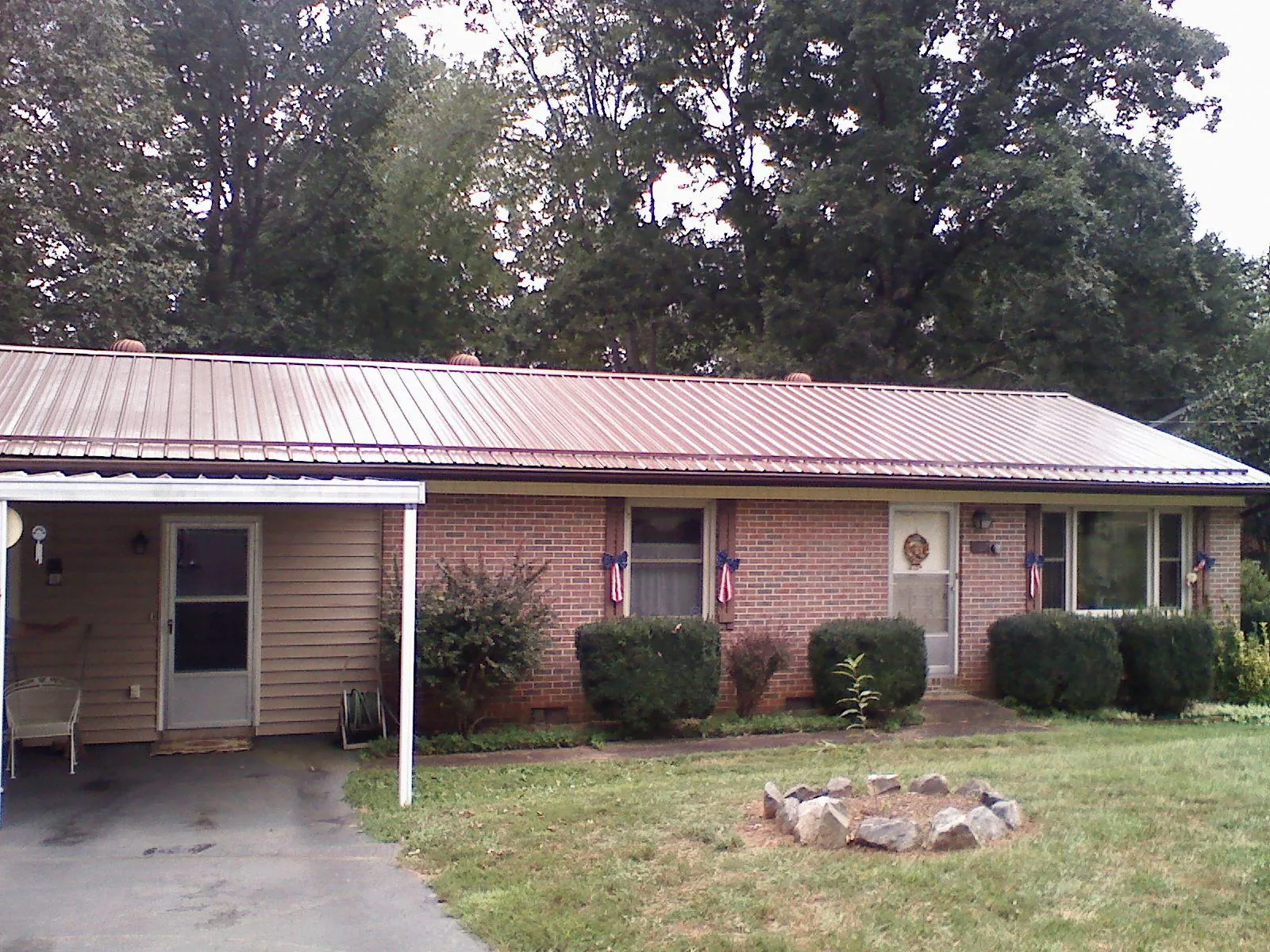 Bronze metal roof and carport on a brick ranch home — Roof Repair work by our crew in Leawood