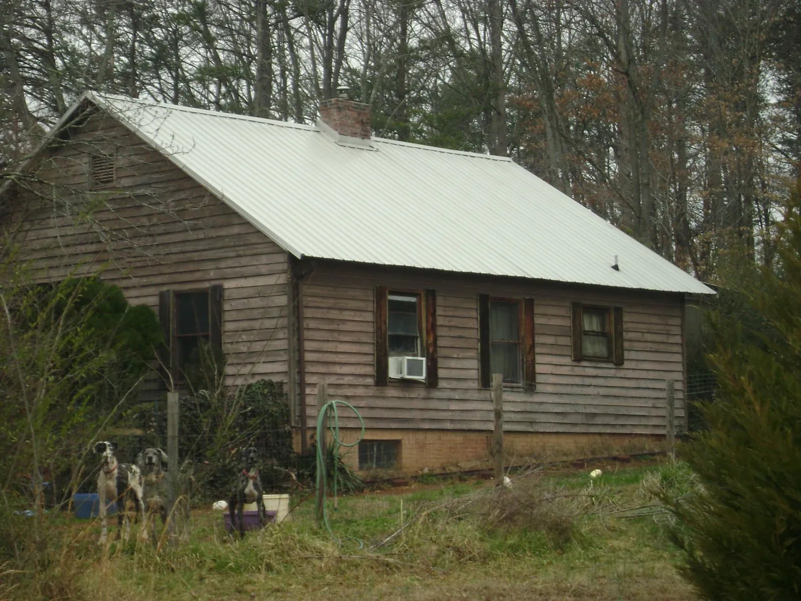 White metal roof on an old wood sided farmhouse, from a Asphalt Shingle Roof Repair job in Leawood